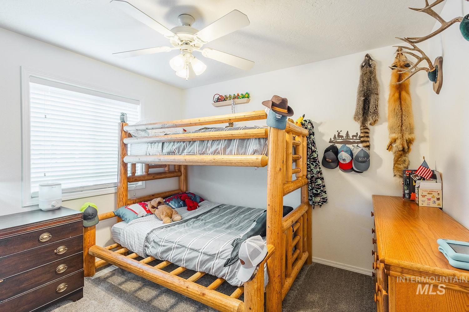 Bedroom featuring dark carpet and ceiling fan