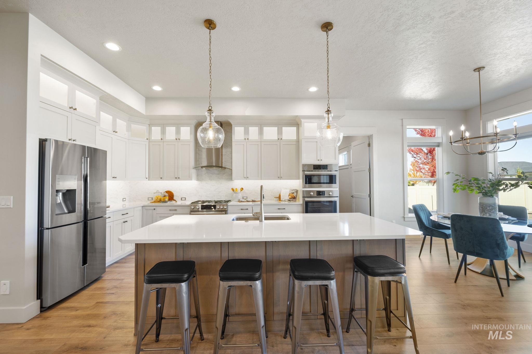 Kitchen with glass insert cabinets, stainless steel appliances, white cabinetry, decorative backsplash, and recessed lighting