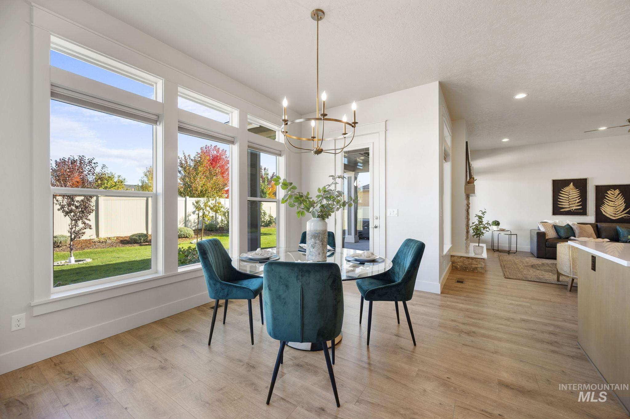 Dining space with light wood-type flooring, a chandelier, and recessed lighting