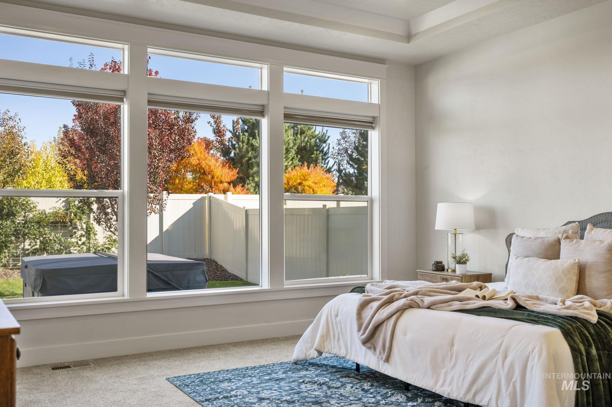 Carpeted bedroom featuring multiple windows
