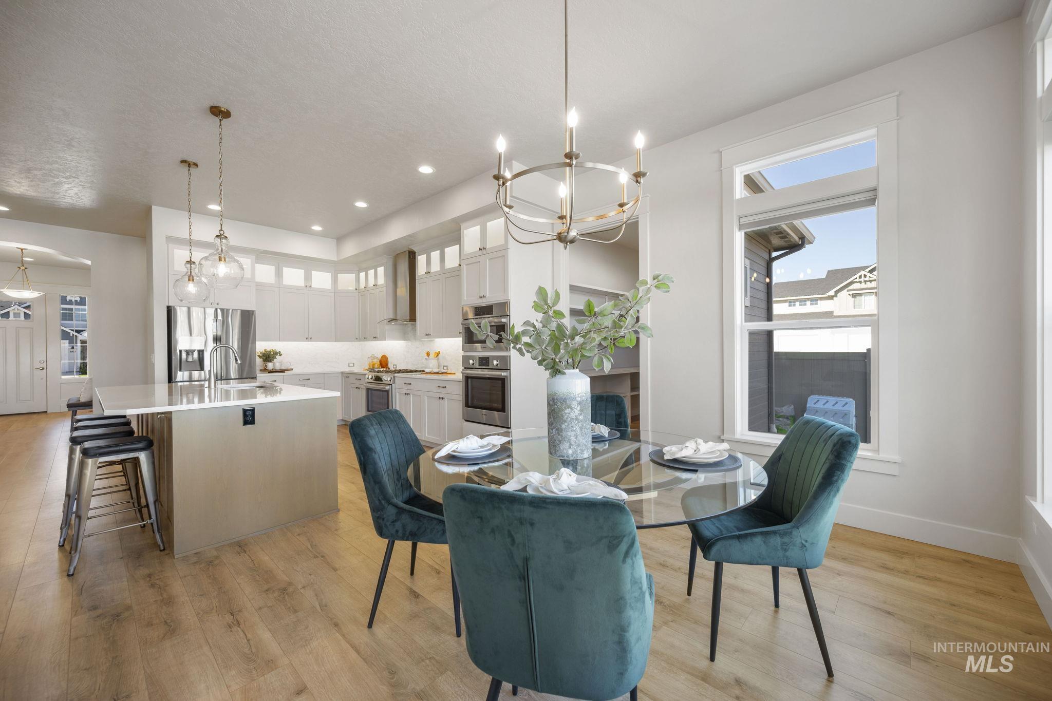 Dining space with a chandelier, light wood-style floors, and recessed lighting