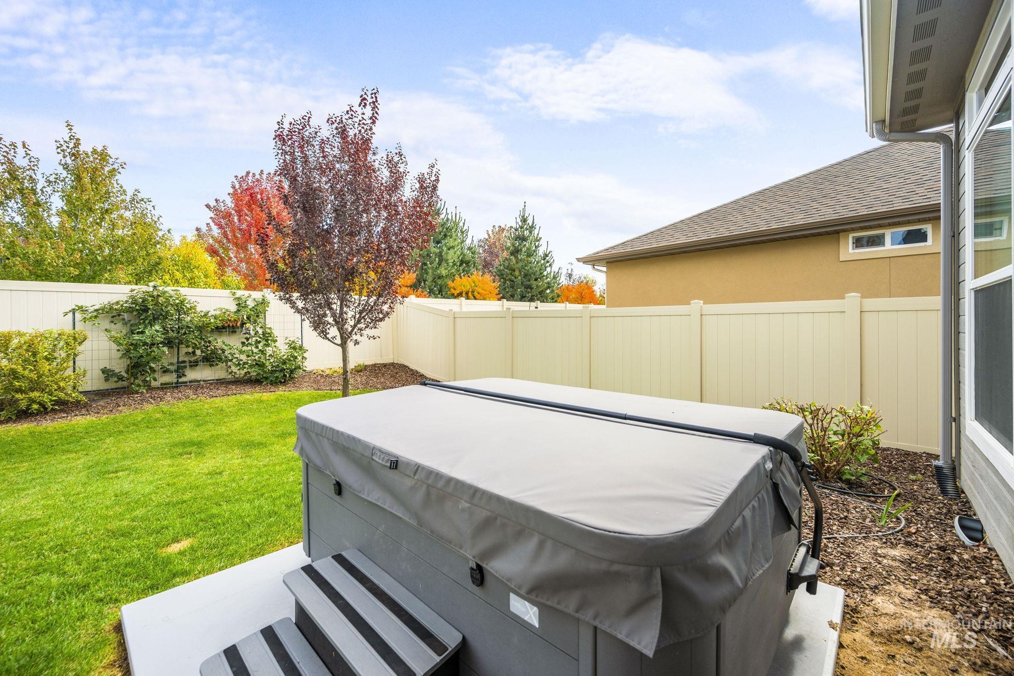 Fenced backyard with a patio area and a hot tub