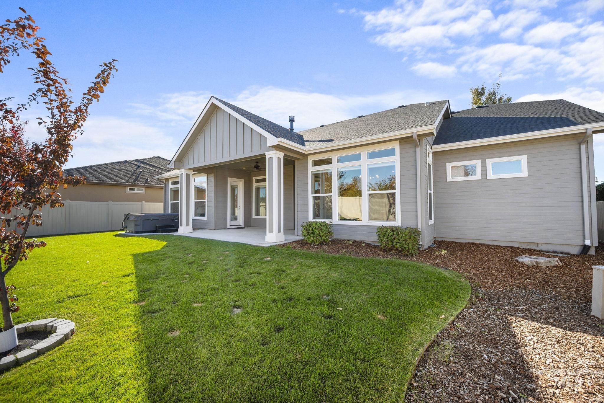 Back of property featuring a hot tub, a fenced backyard, a patio, ceiling fan, and roof with shingles