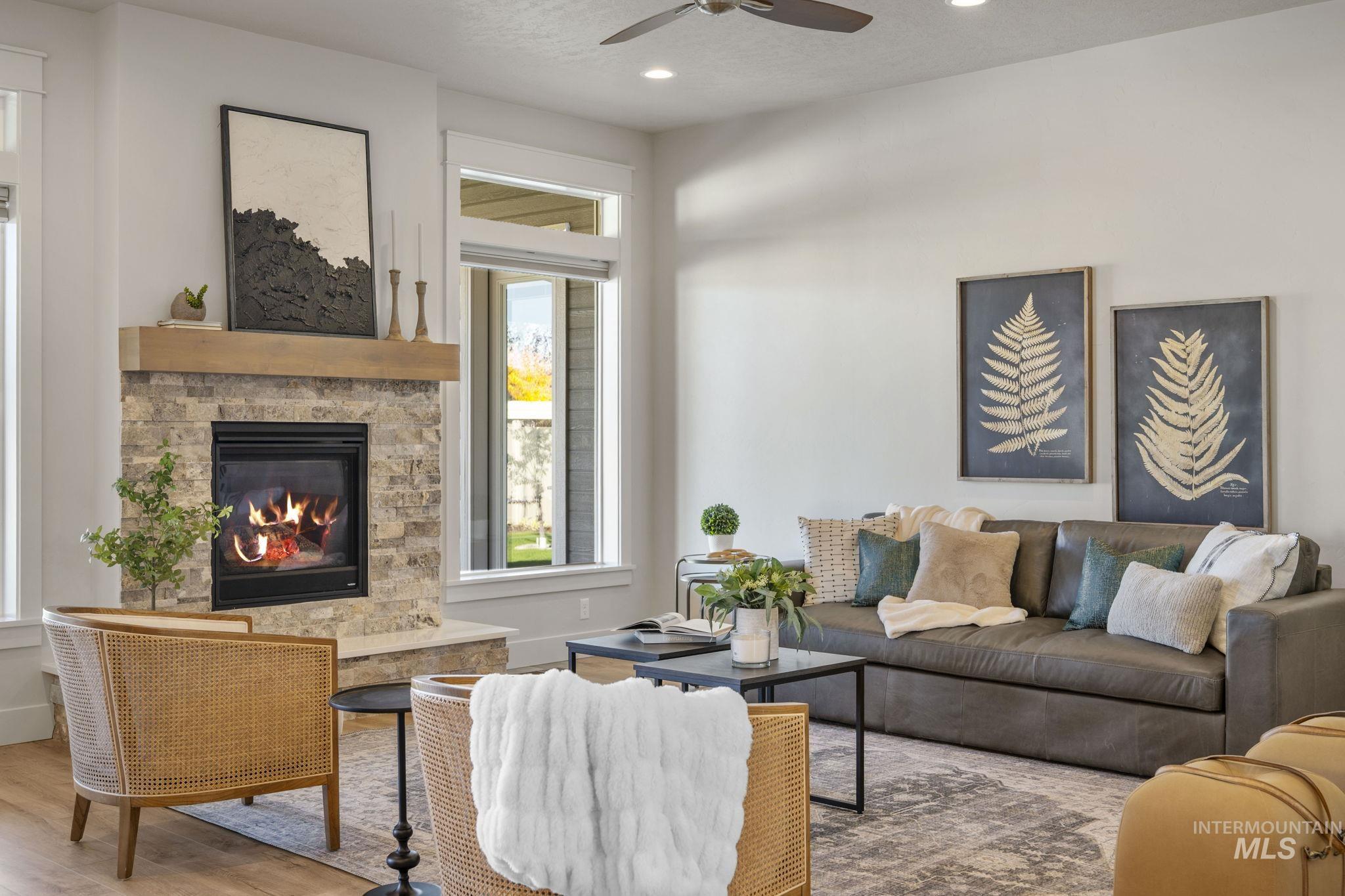 Living room featuring recessed lighting, wood finished floors, a fireplace, ceiling fan, and a textured ceiling