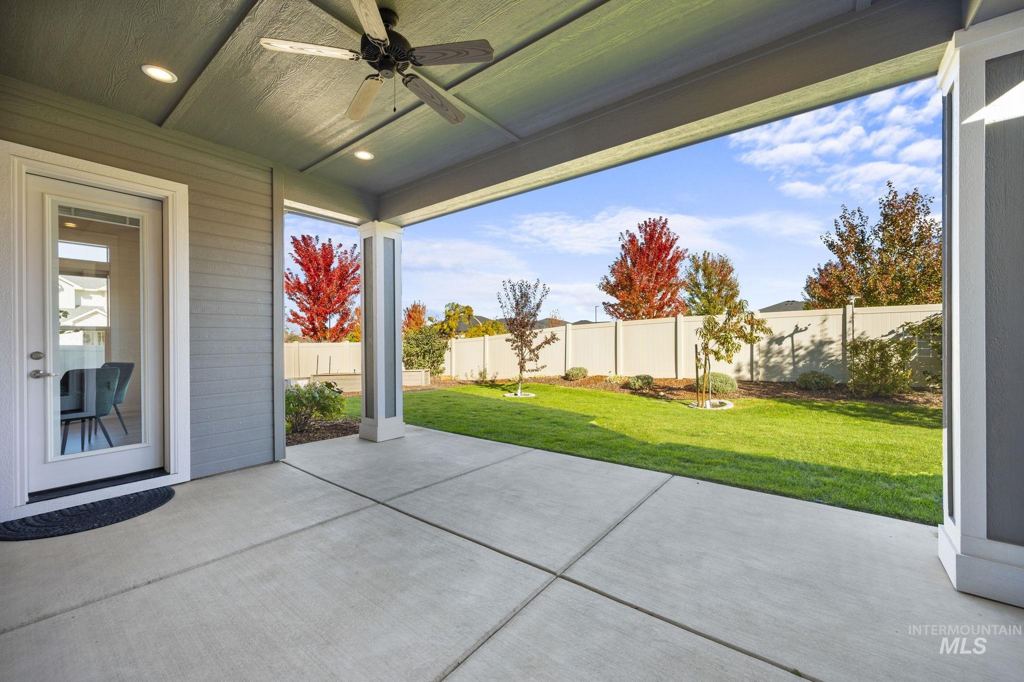 Fenced backyard with ceiling fan and a patio area