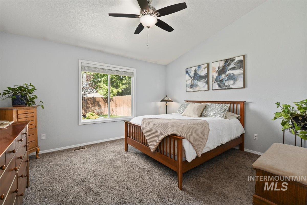 Primary suite with vaulted ceiling and ceiling fan