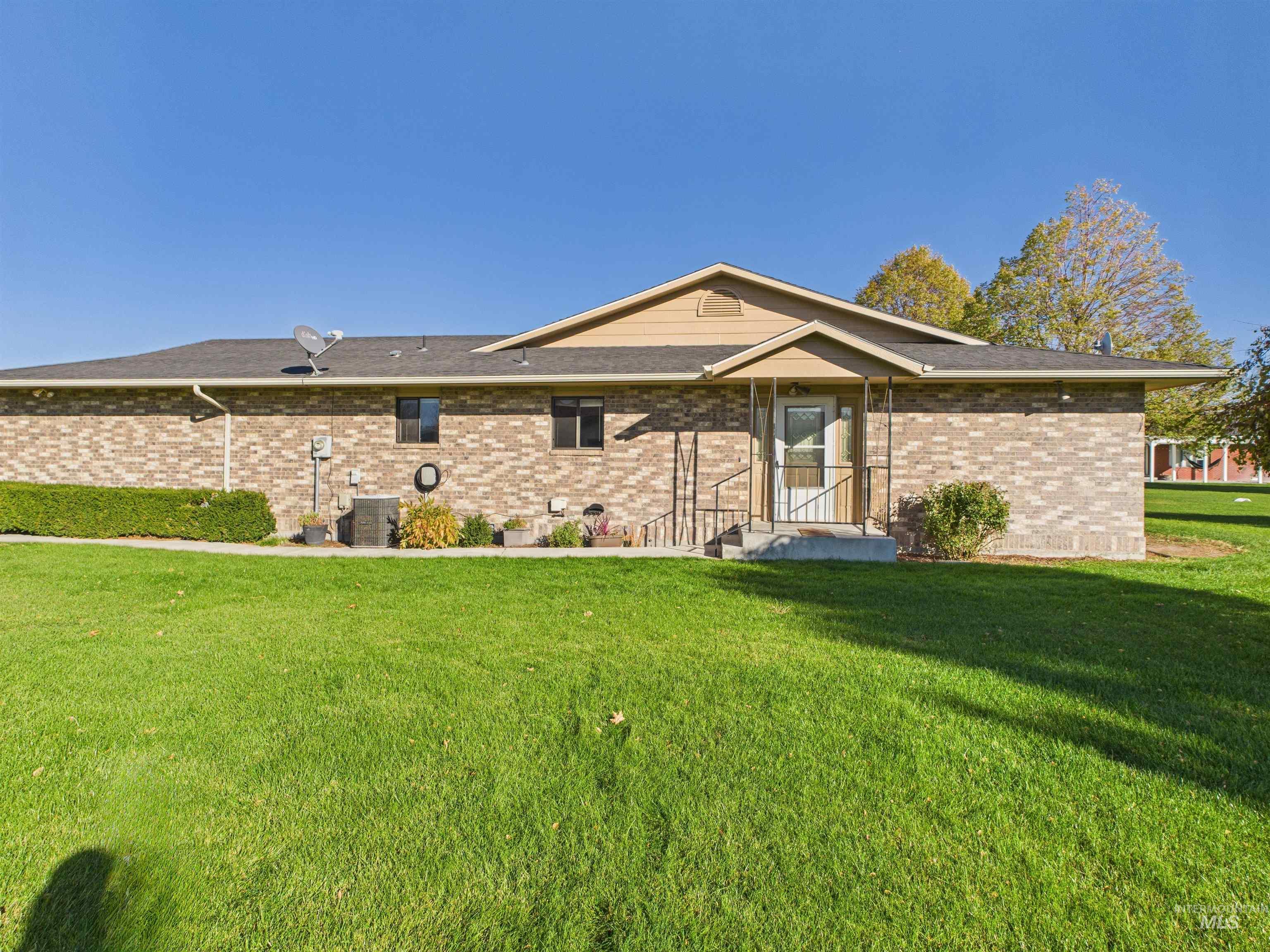 Rear view of property with a yard and brick siding