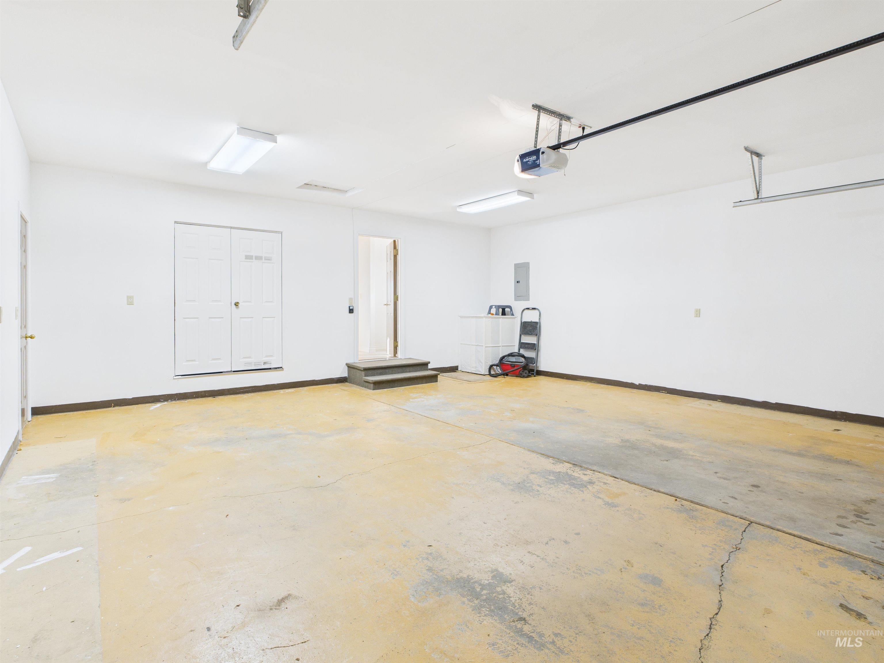 Garage featuring a garage door opener and electric panel
