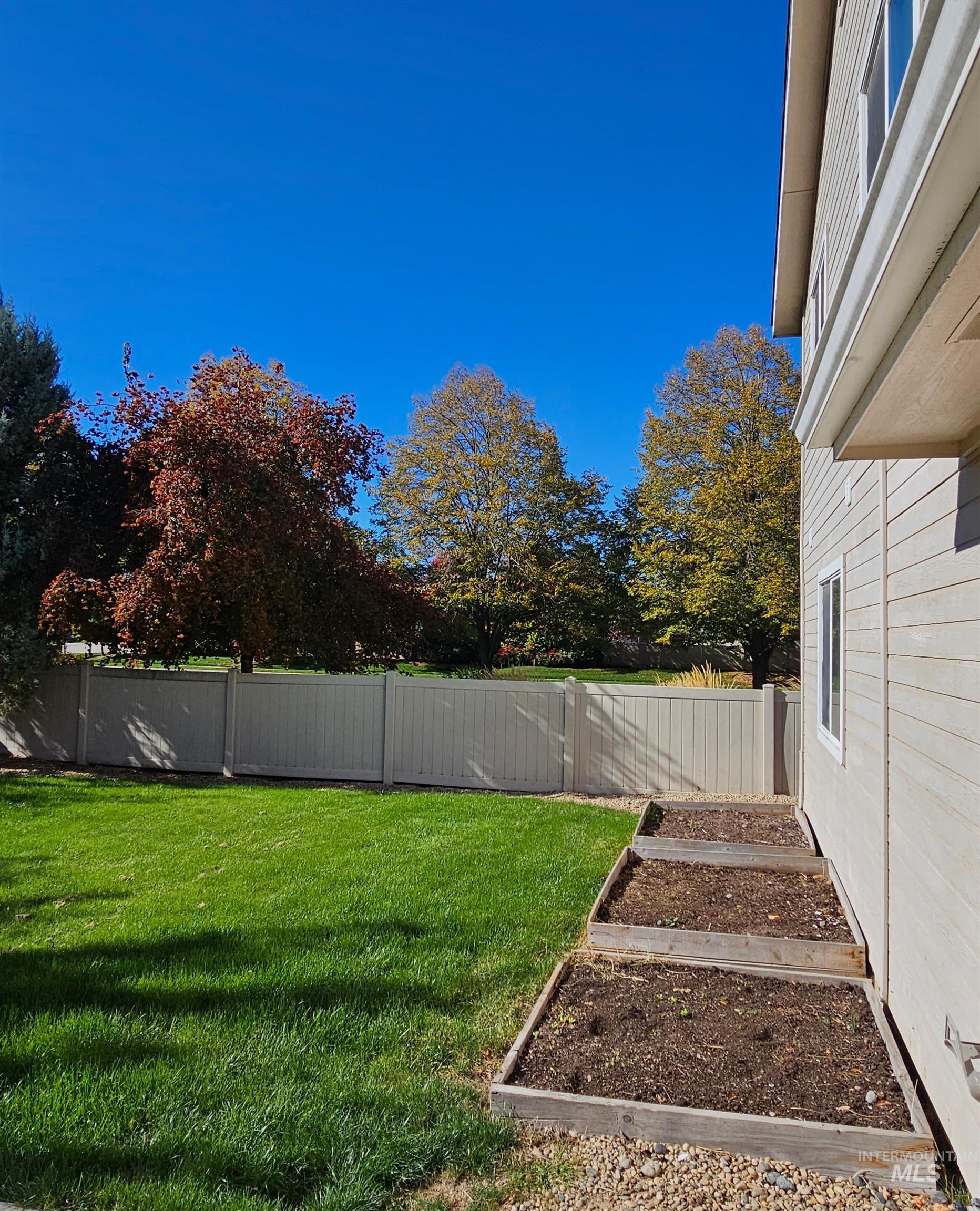 Fenced backyard with a vegetable garden