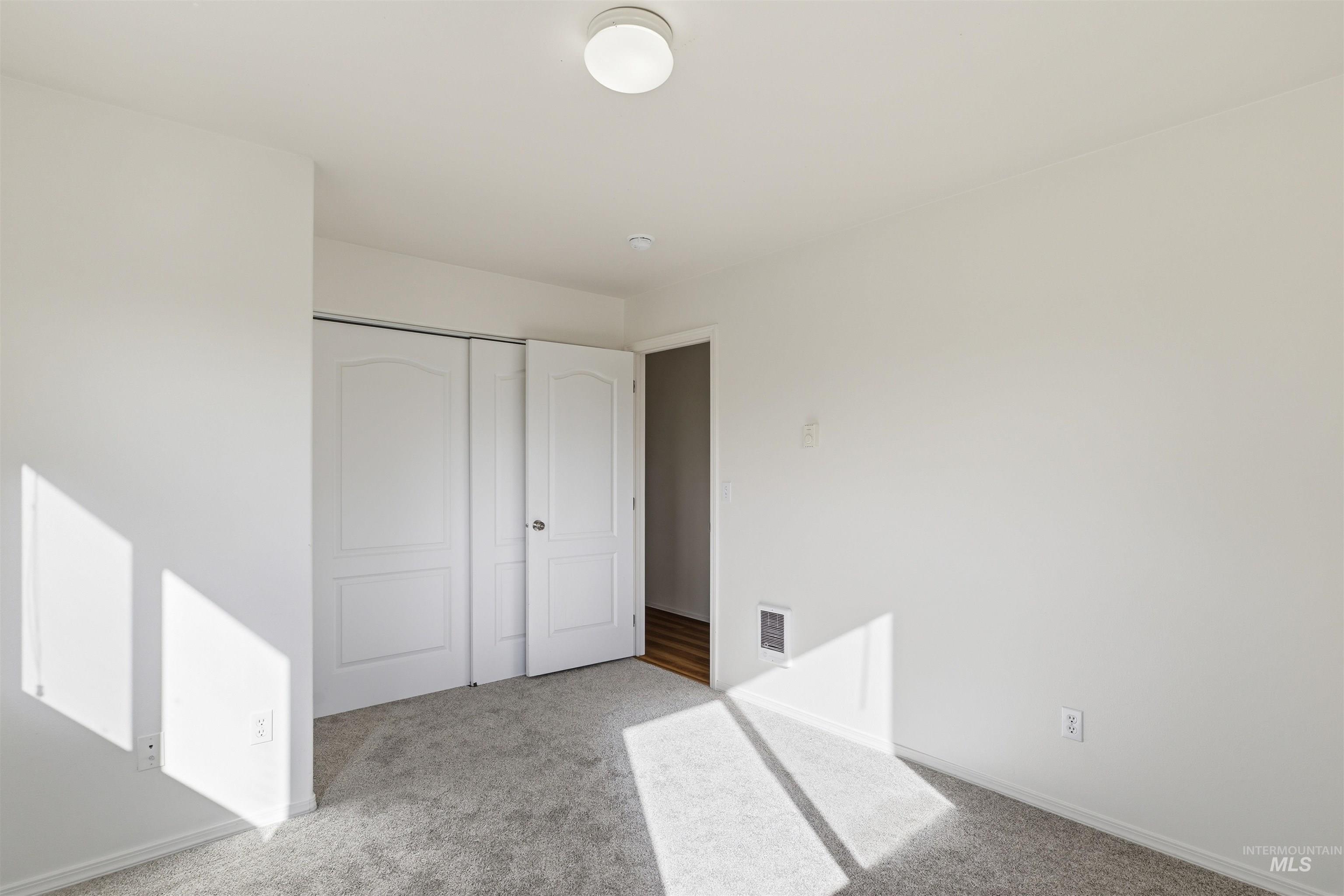 Unfurnished bedroom featuring carpet flooring and a closet