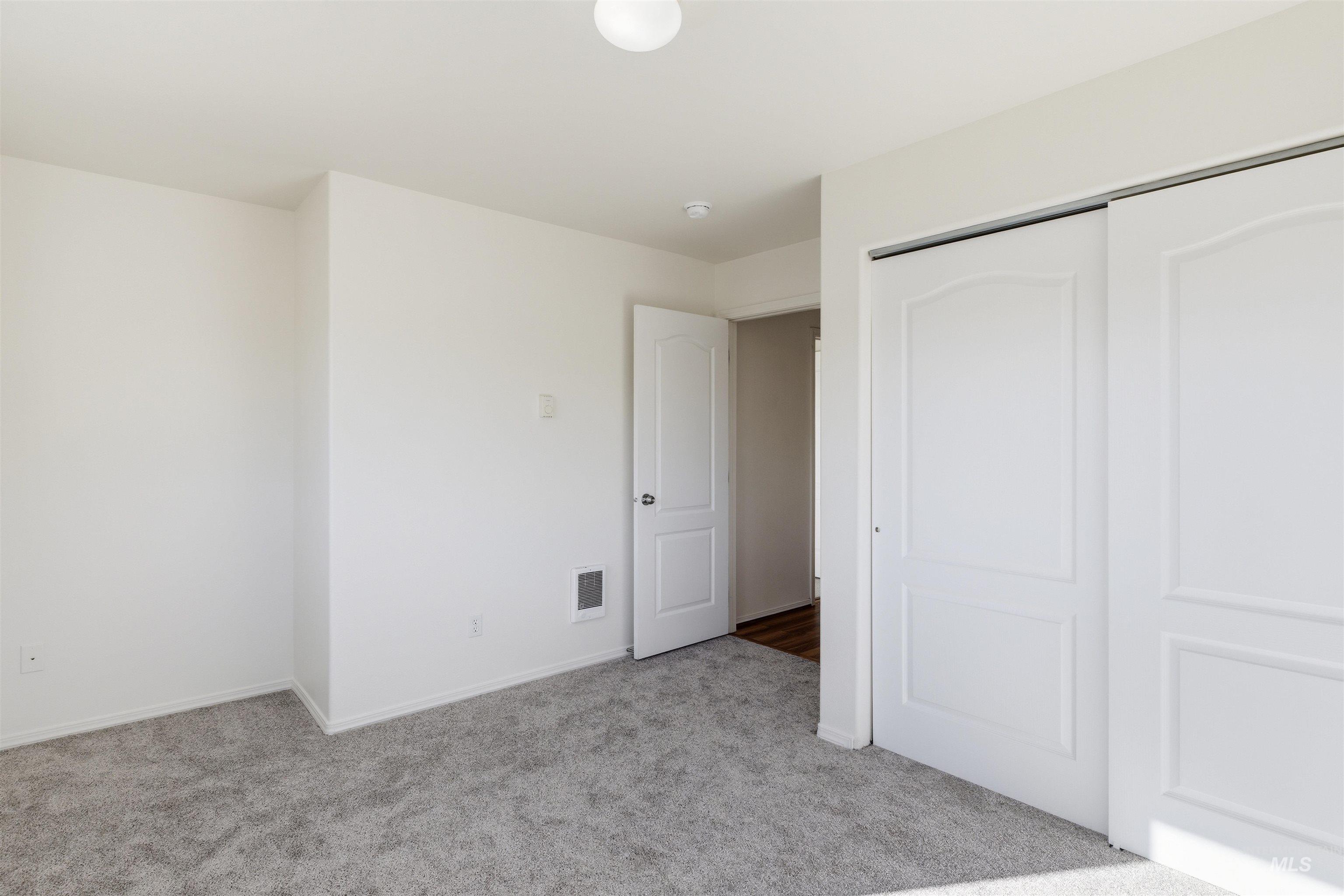 Unfurnished bedroom with light colored carpet and a closet