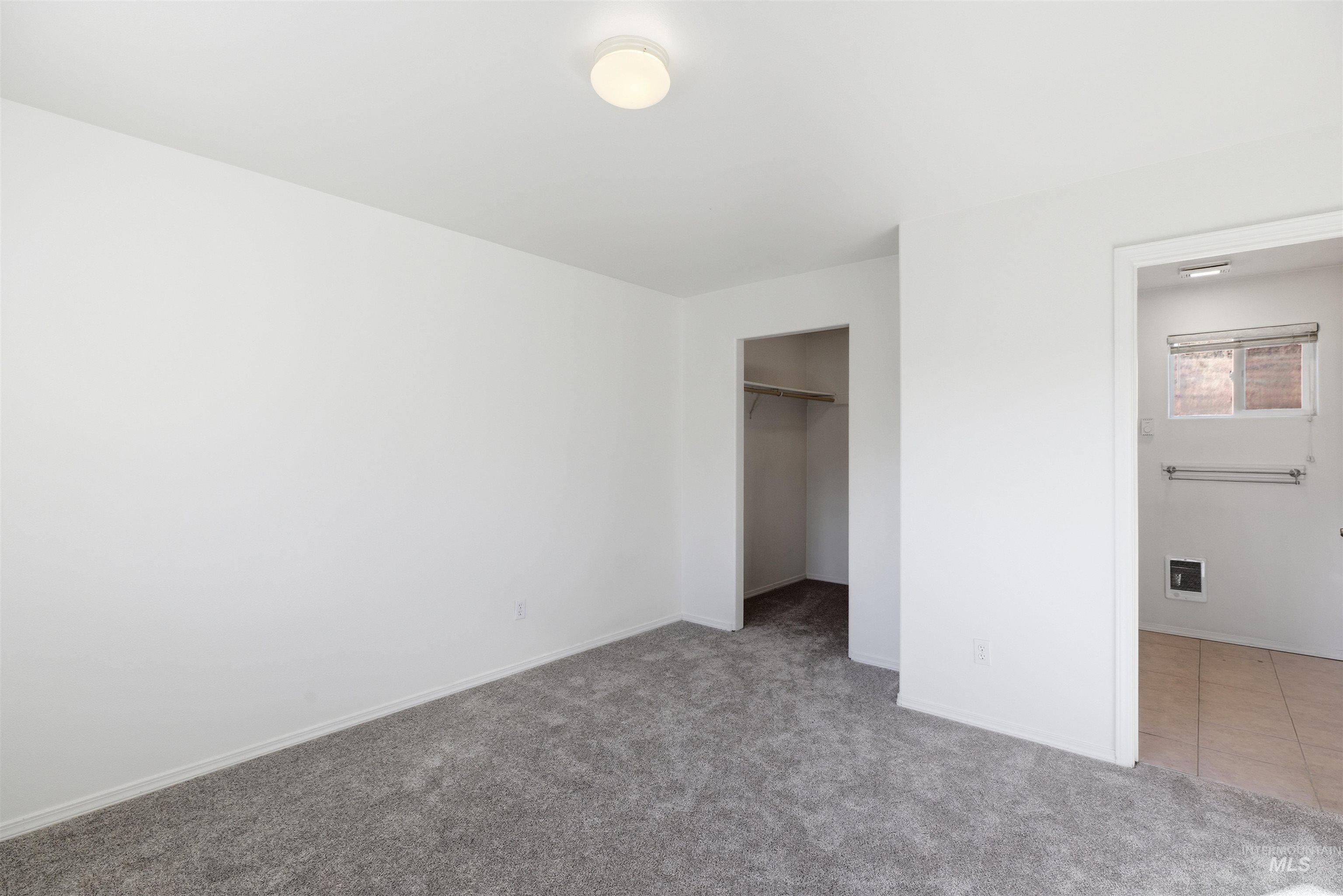 Unfurnished bedroom with carpet floors and a walk in closet