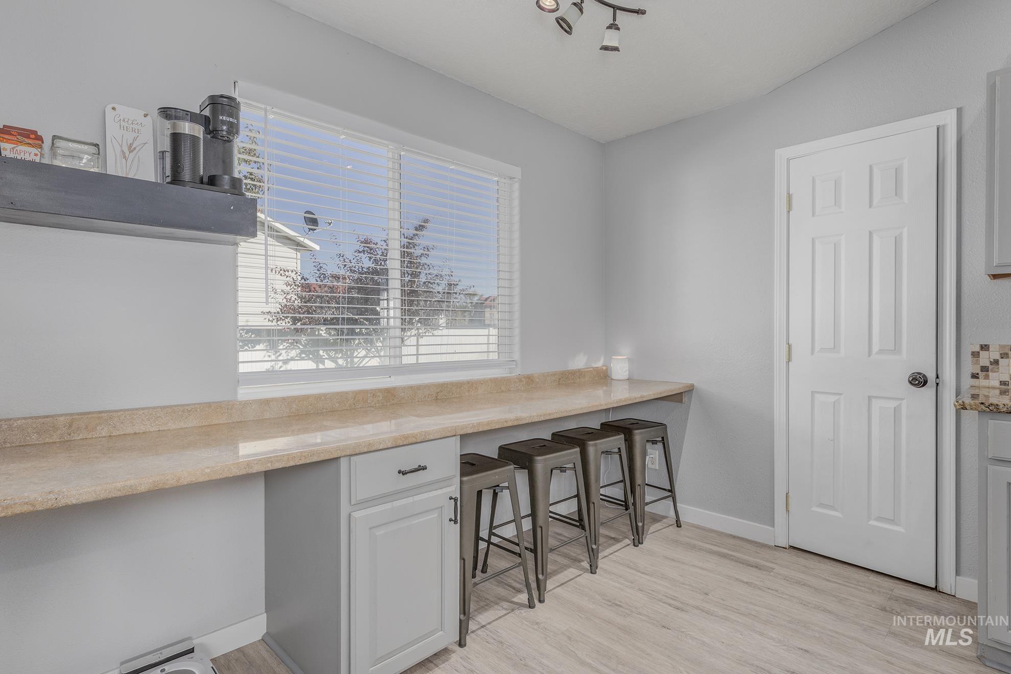 Unfurnished dining area featuring light wood-style flooring and built in desk