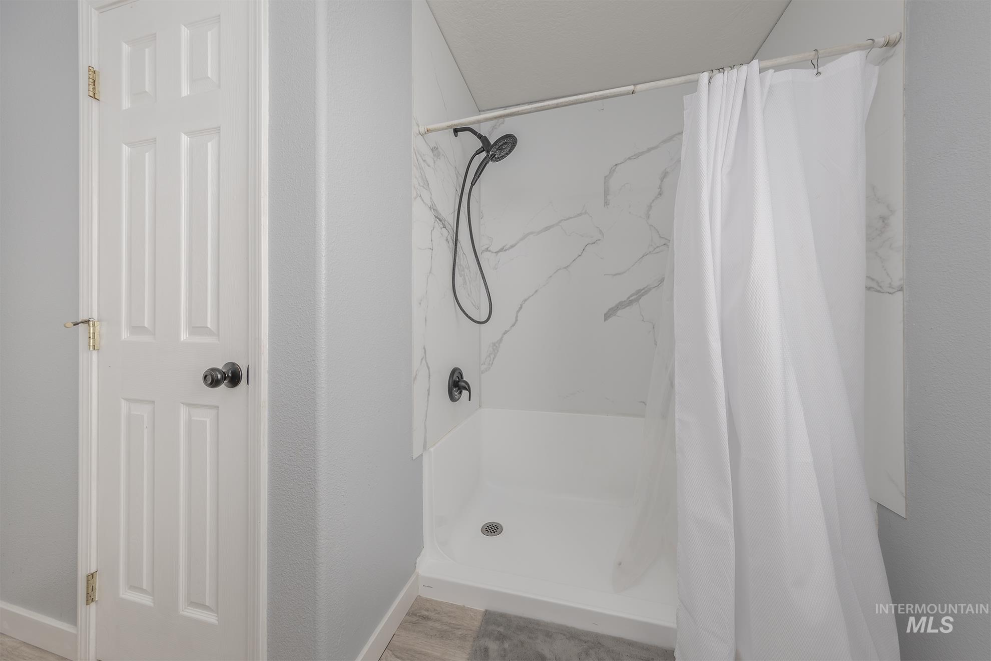 Bathroom with a stall shower and wood finished floors