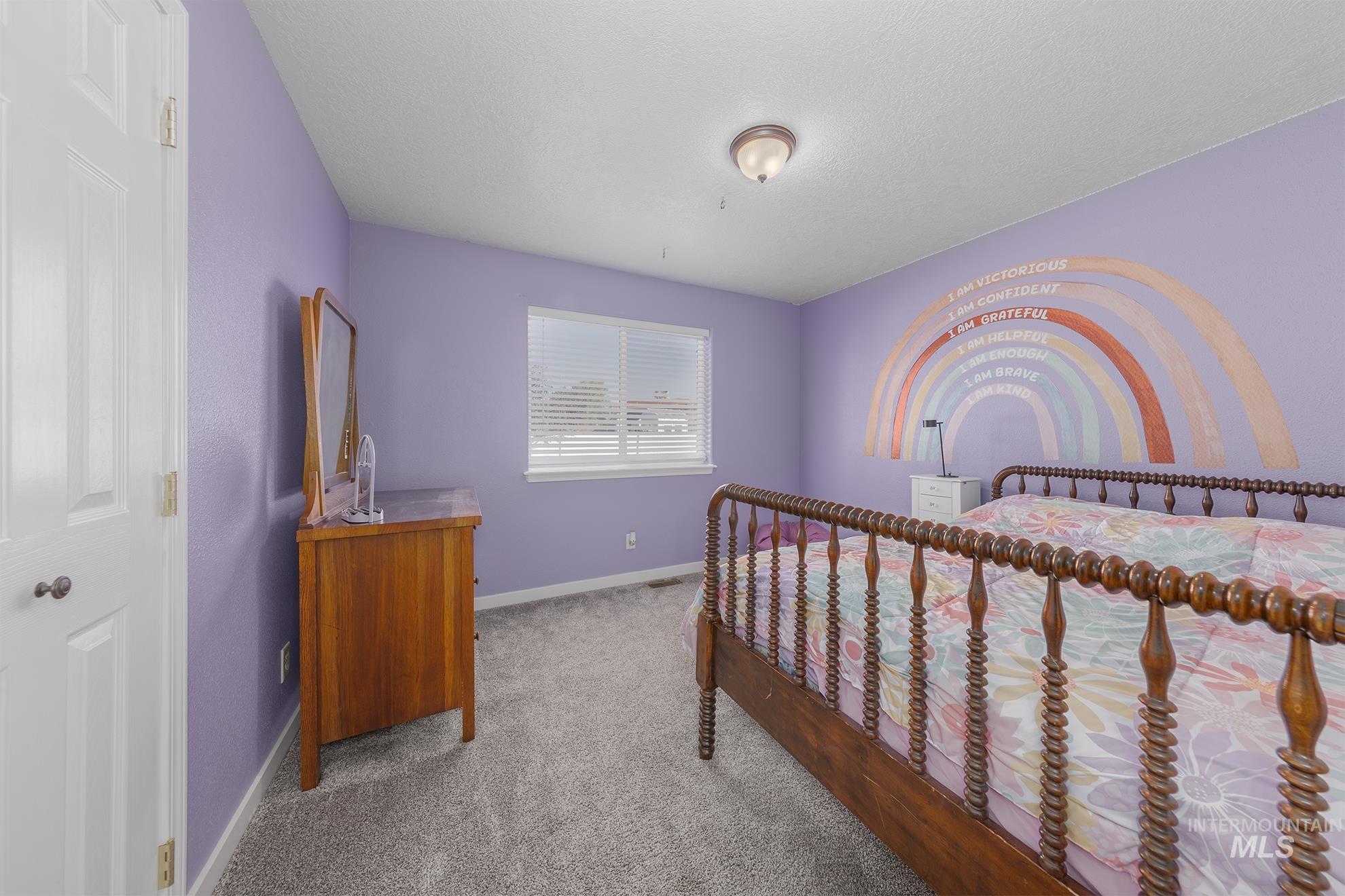 Bedroom featuring carpet and a textured ceiling