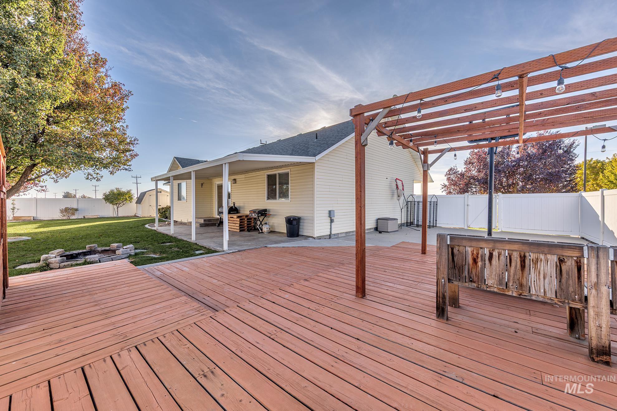 Wooden terrace featuring a patio area, an outdoor fire pit, a fenced backyard, and a pergola
