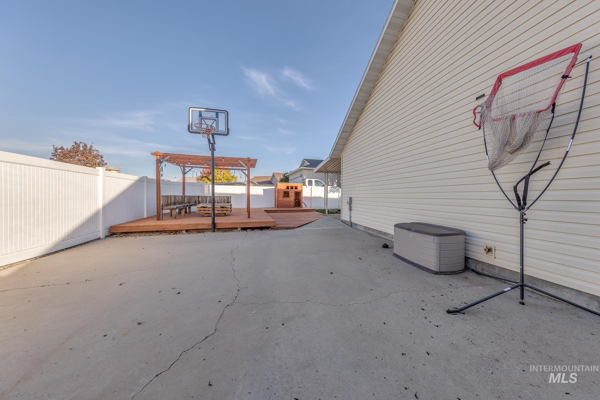 Fenced backyard featuring a deck, a patio area, and a pergola