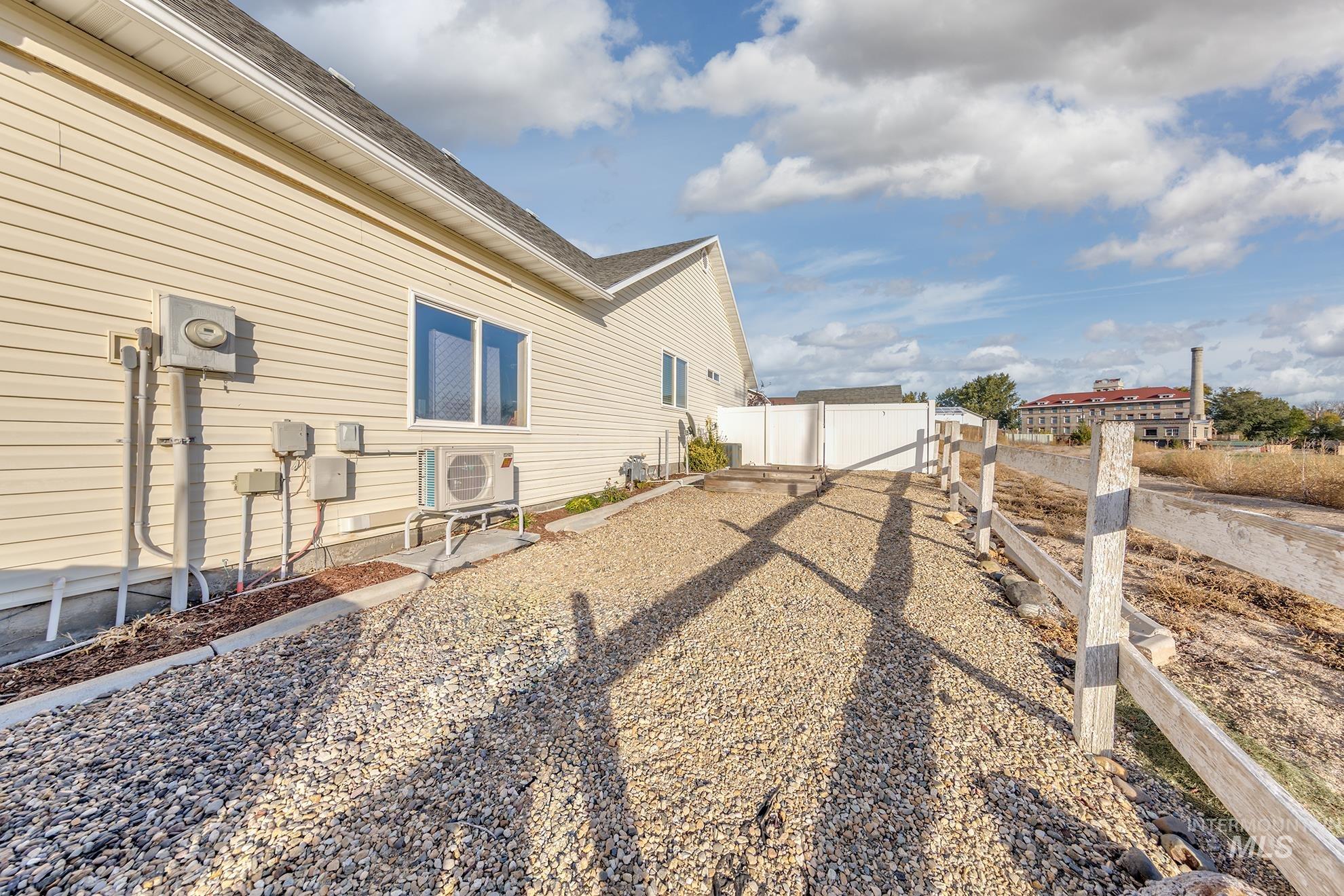 View of side of property featuring a fenced backyard and roof with shingles