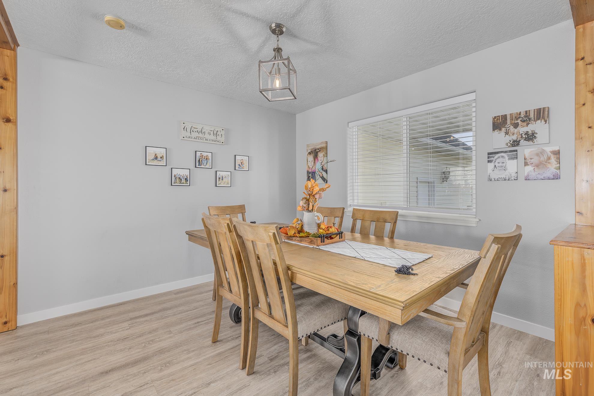 Dining space featuring a textured ceiling and light wood finished floors