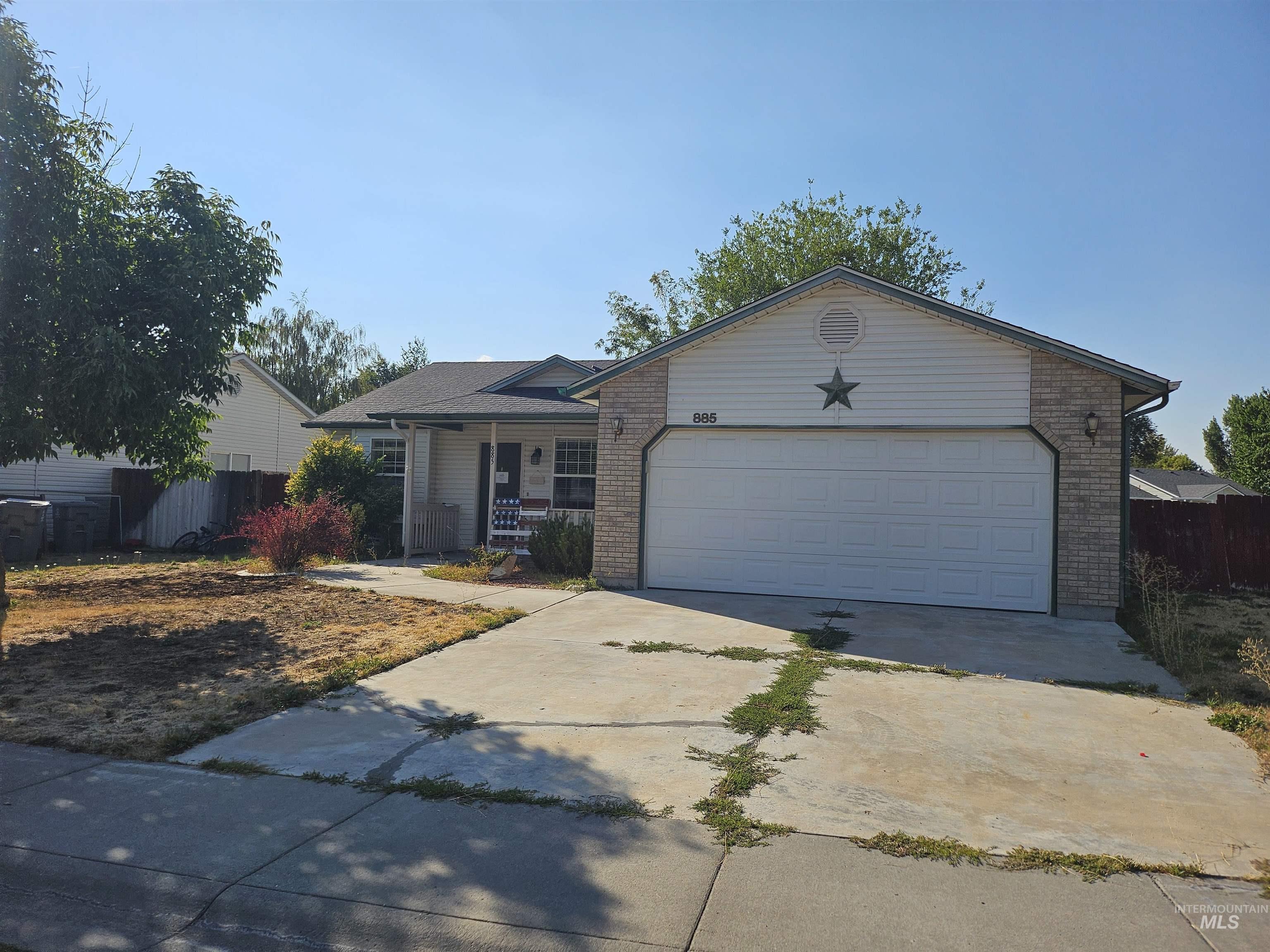 Ranch-style house with concrete driveway, a porch, brick siding, and a garage