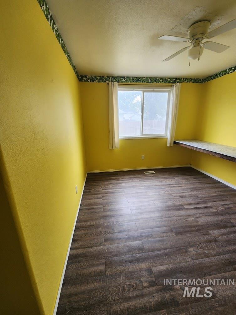 Unfurnished room with baseboards and dark wood finished floors