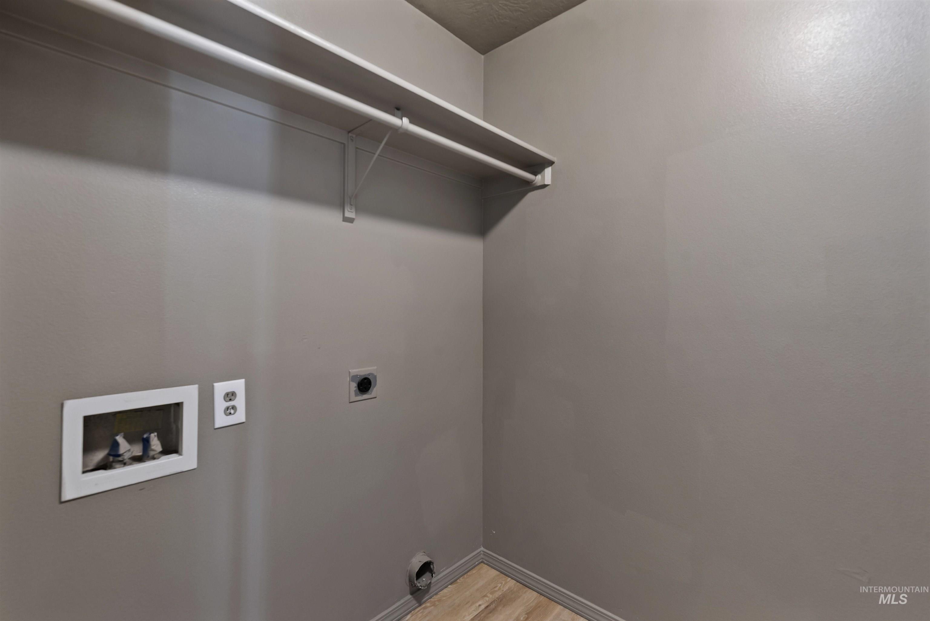Laundry room with washer hookup, electric dryer hookup, and light wood-style flooring