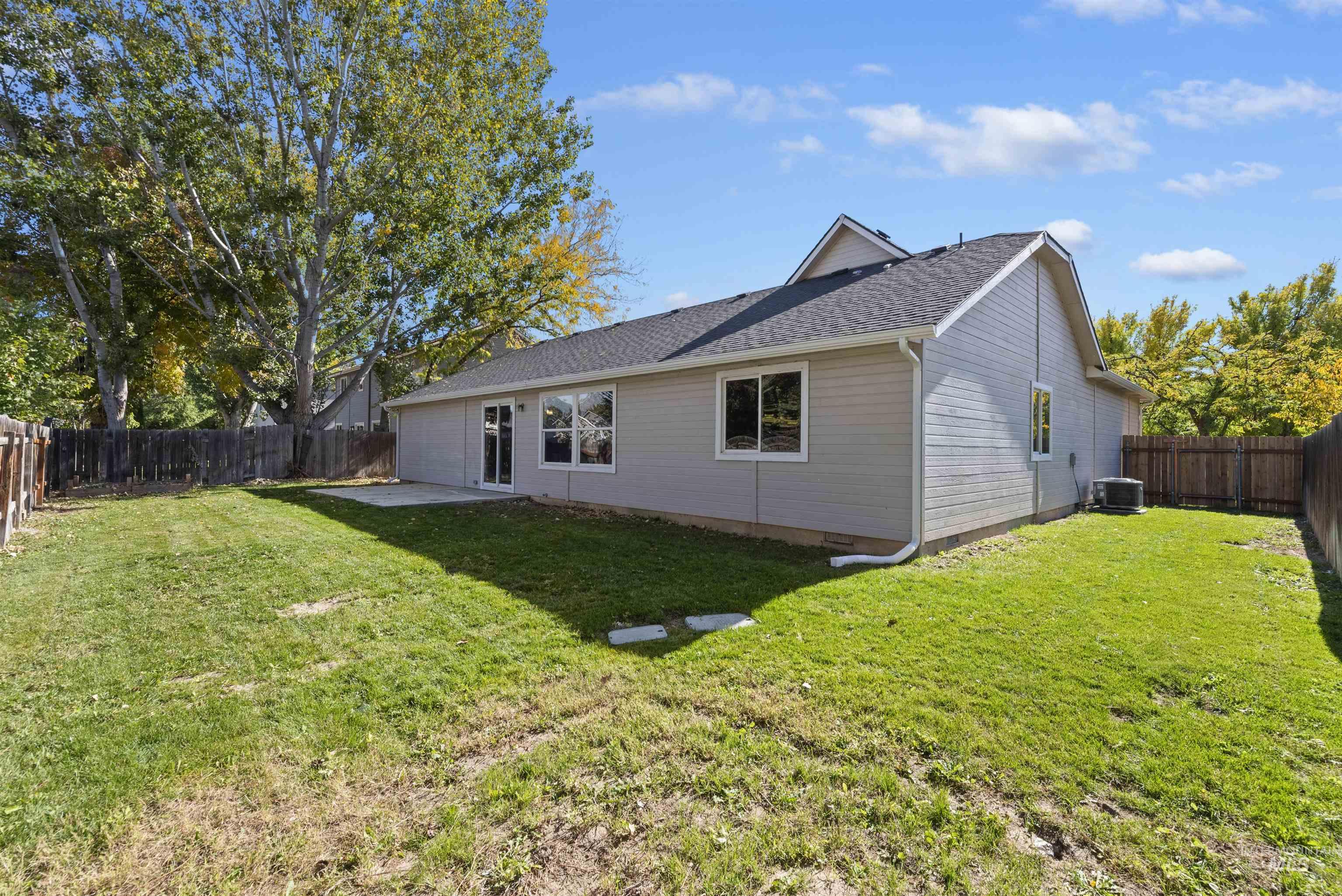 Back of property featuring a fenced backyard, a patio area, and a shingled roof