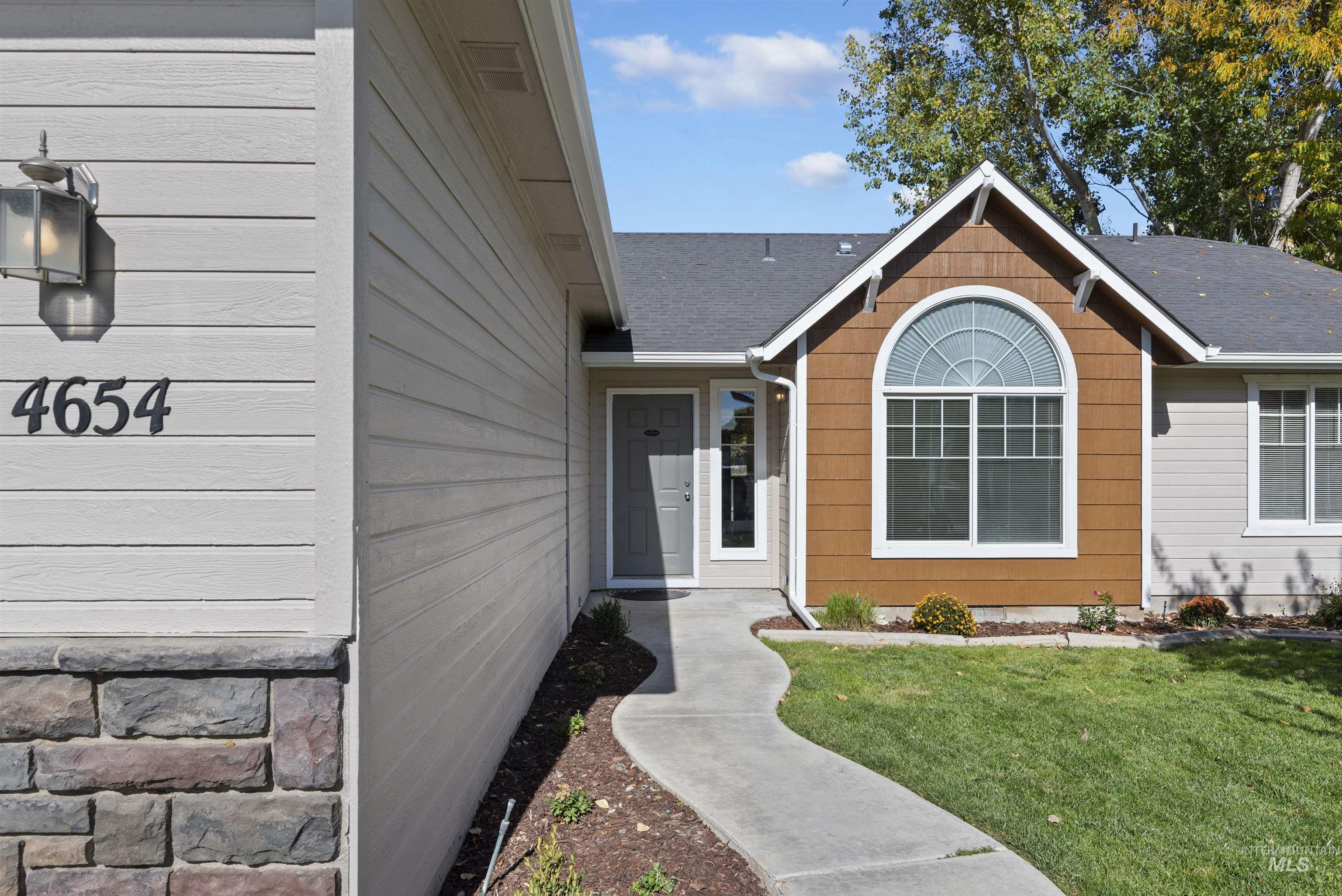 Entrance to property with a yard and roof with shingles