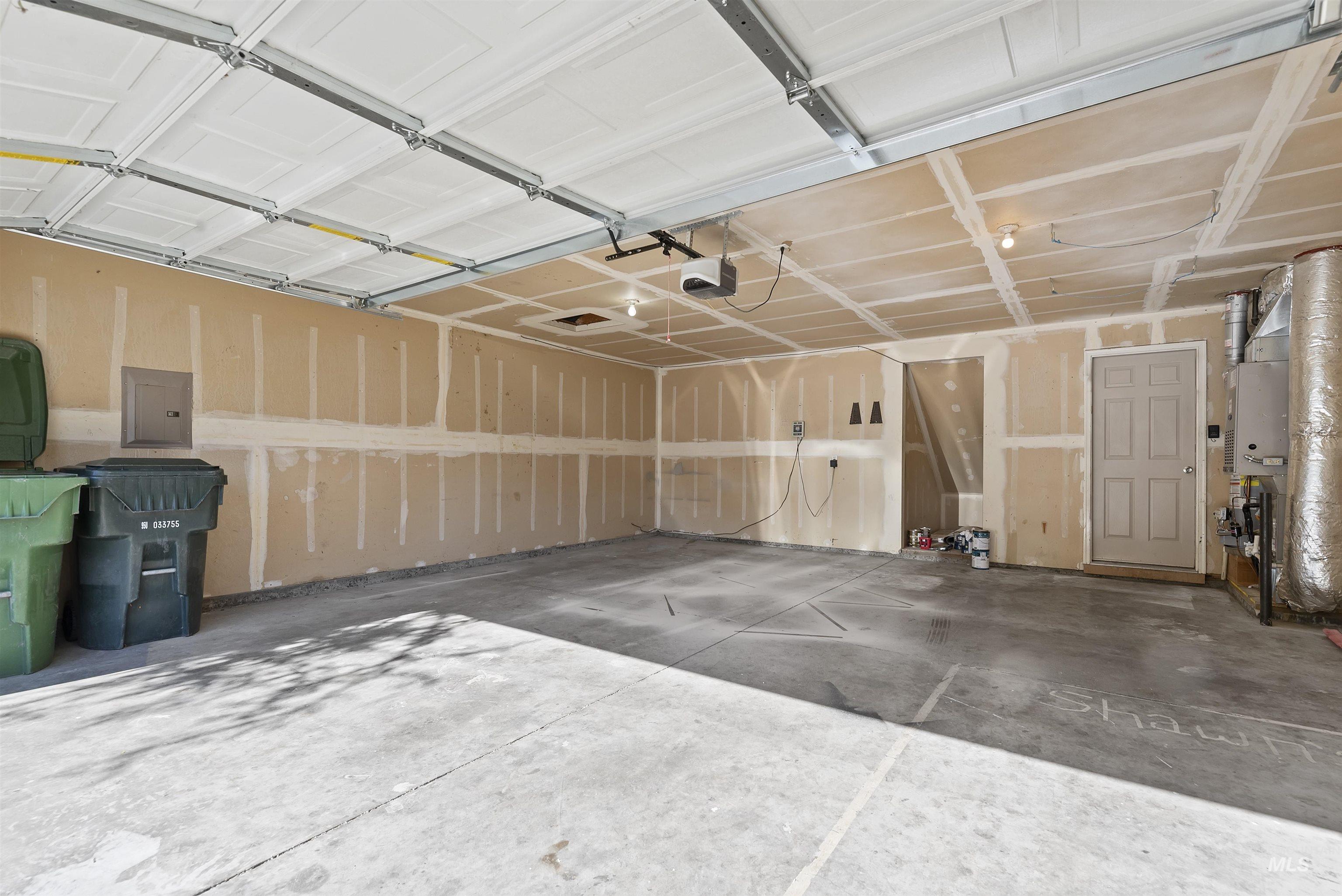 Garage with electric panel and a garage door opener