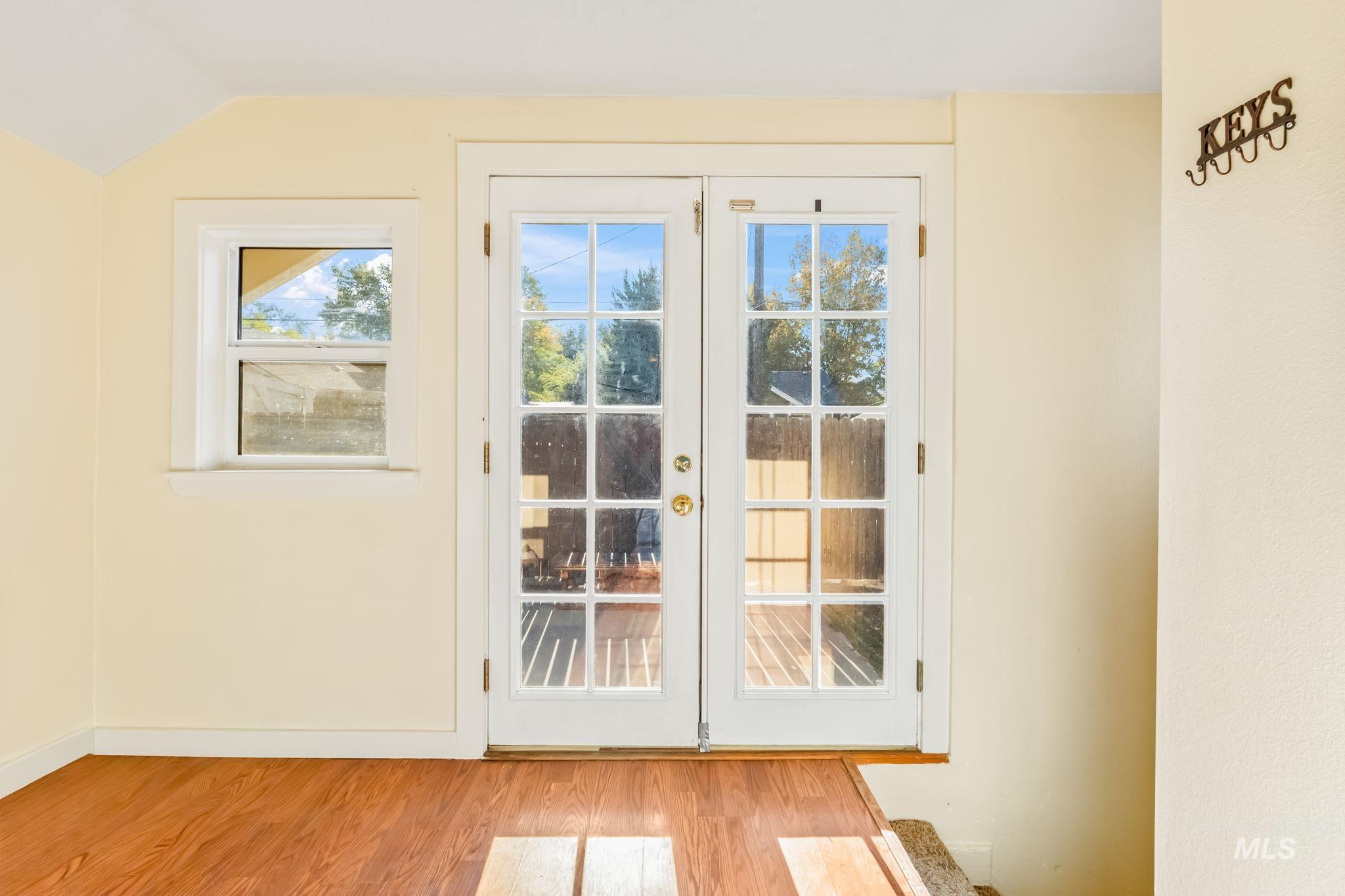 Doorway to outside with wood finished floors and french doors