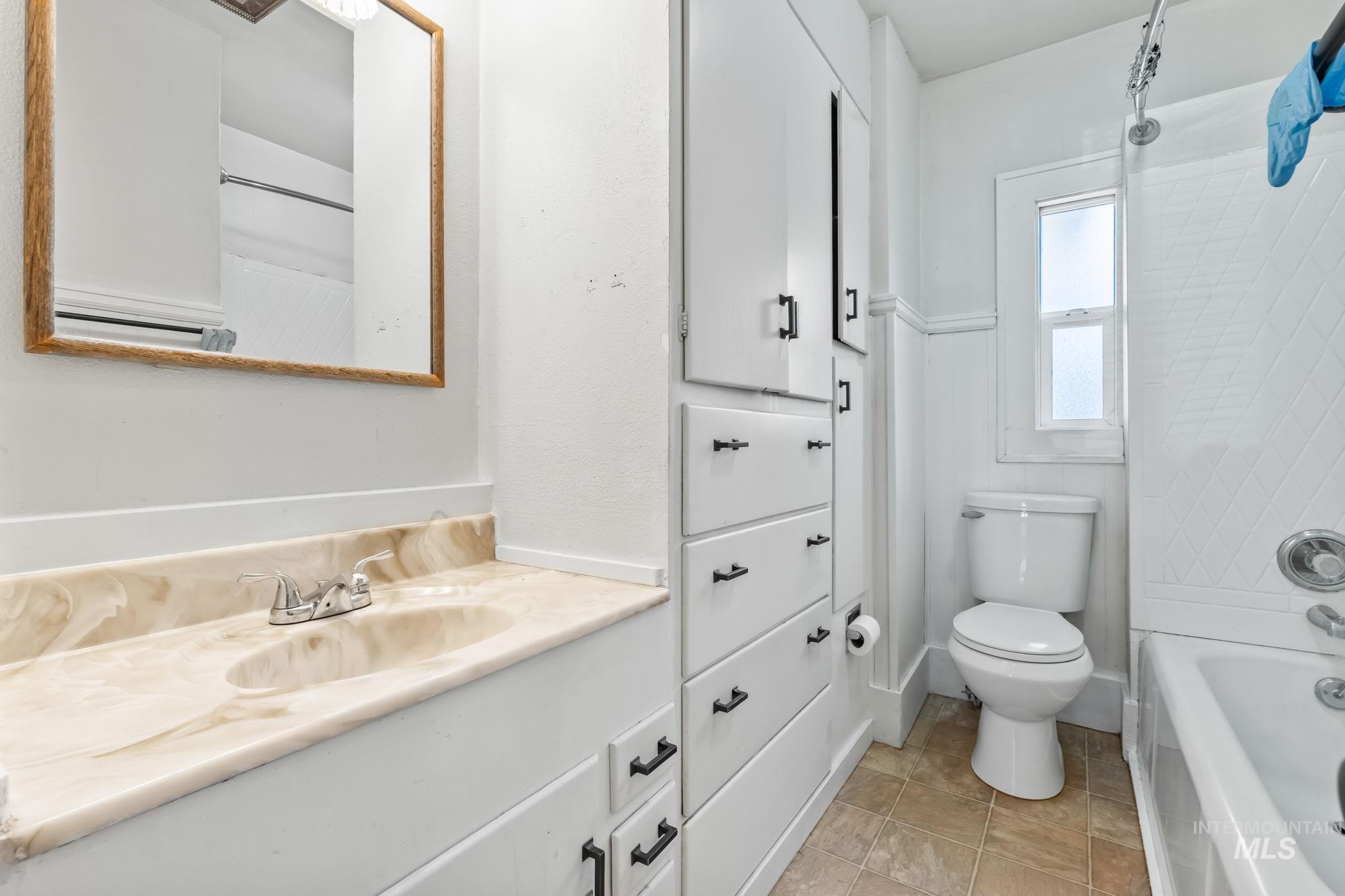 Bathroom featuring vanity, light tile patterned floors, and shower / bathtub combination