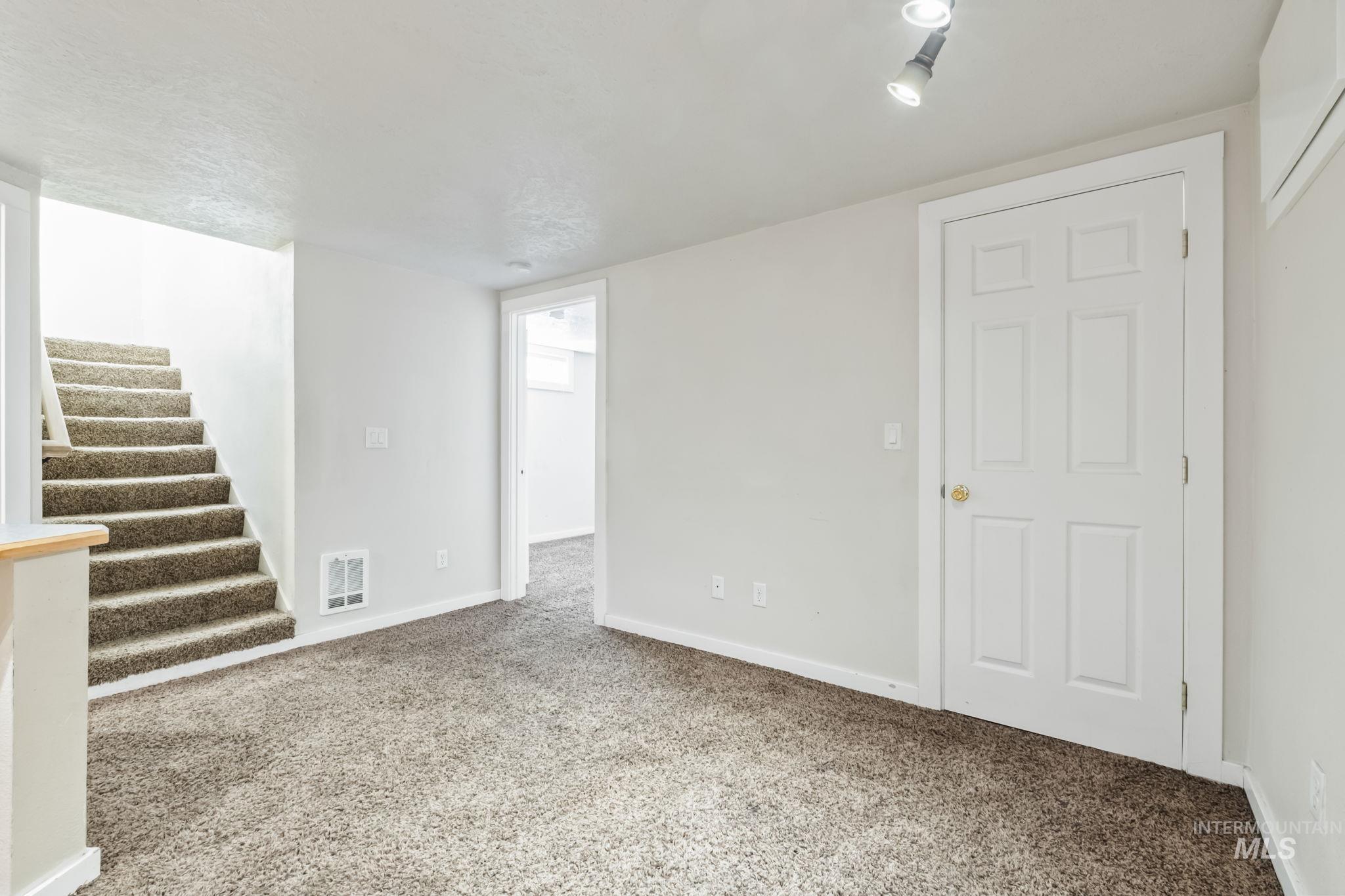 Finished below grade area featuring carpet and stairway