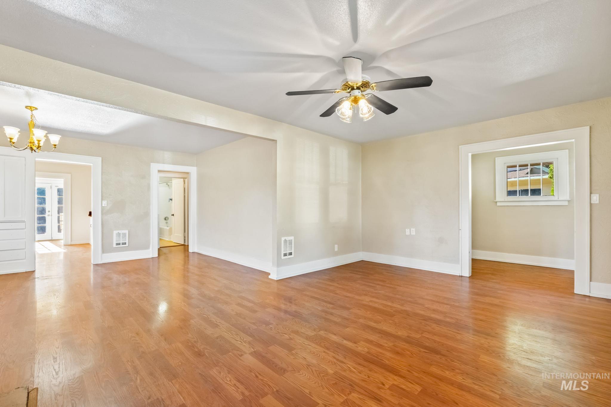 Spare room featuring light wood-type flooring and a chandelier