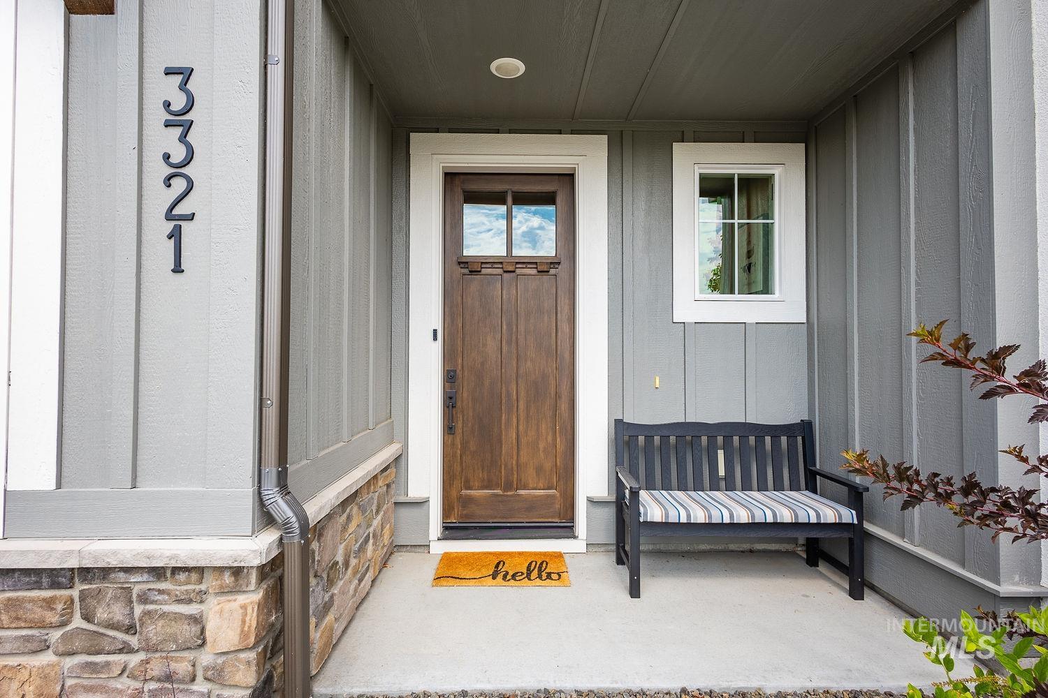 View of exterior entry featuring board and batten siding and stone siding