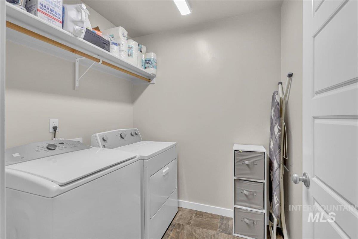 Washroom with washer and dryer and baseboards