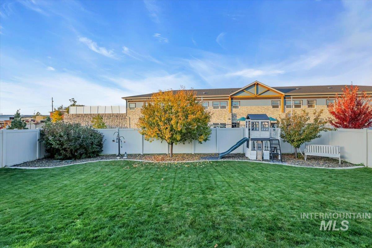 Rear view of property with a fenced backyard, a playground, and a patio area