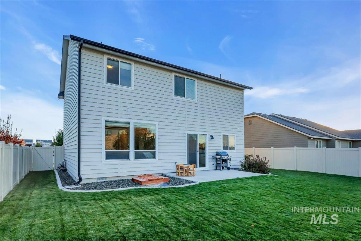 Rear view of property with a fenced backyard and a patio area