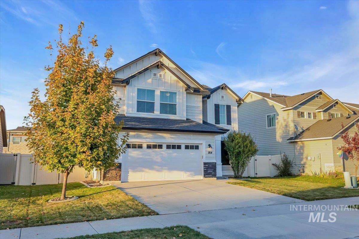 Craftsman inspired home with board and batten siding, driveway, and an attached garage