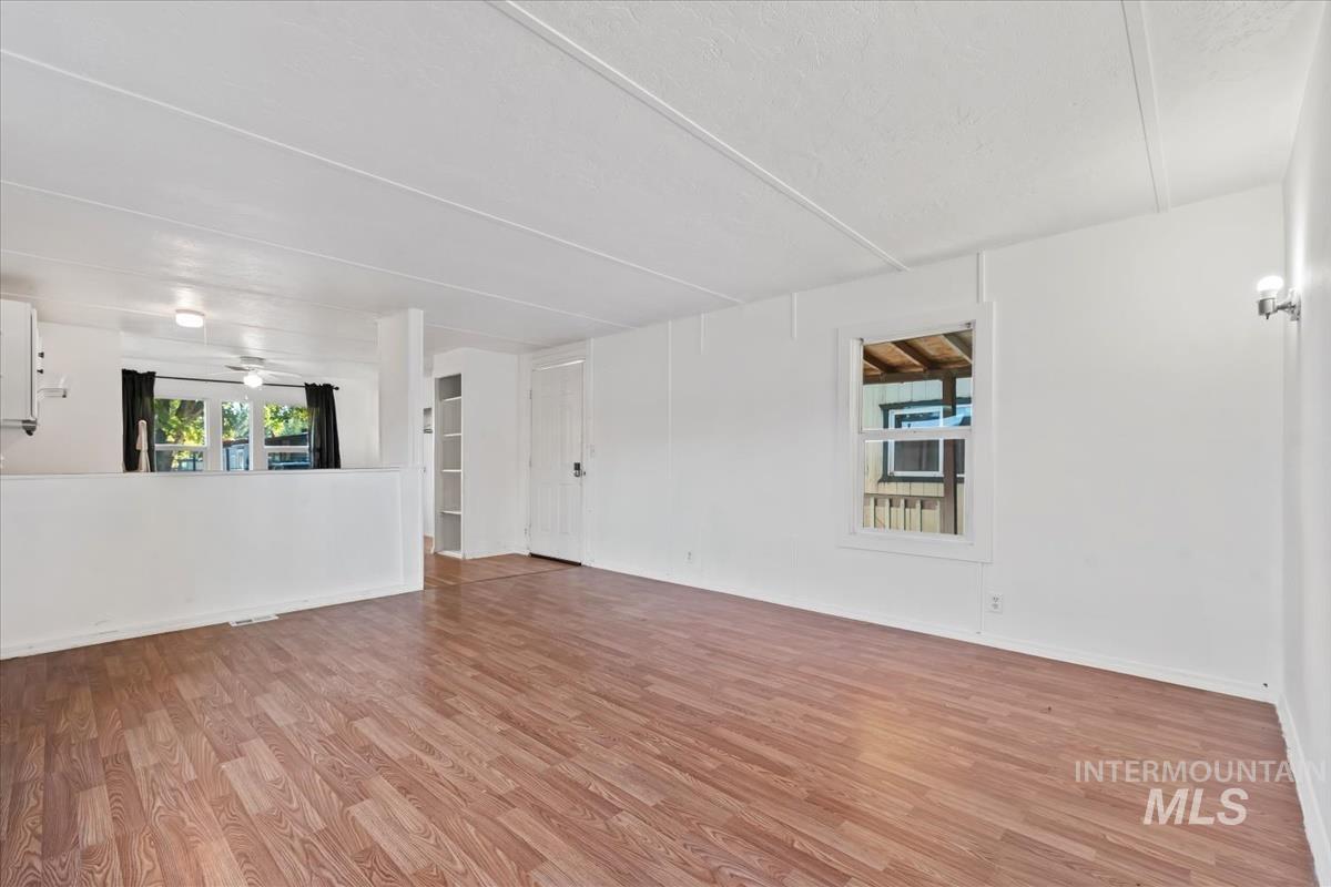 Spare room with plenty of natural light, light wood-type flooring, and a ceiling fan