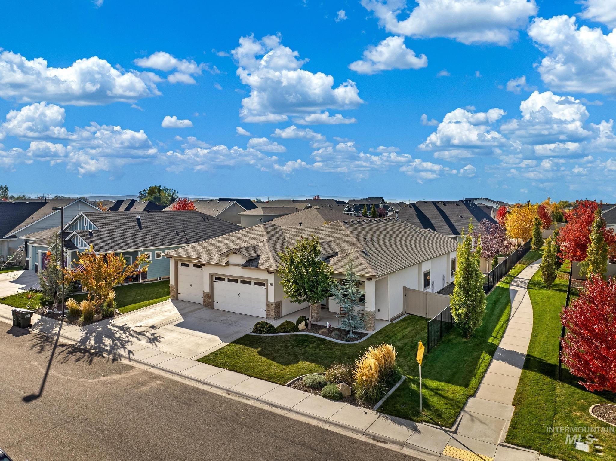 View of front of house with a residential view, concrete driveway, and an attached garage
