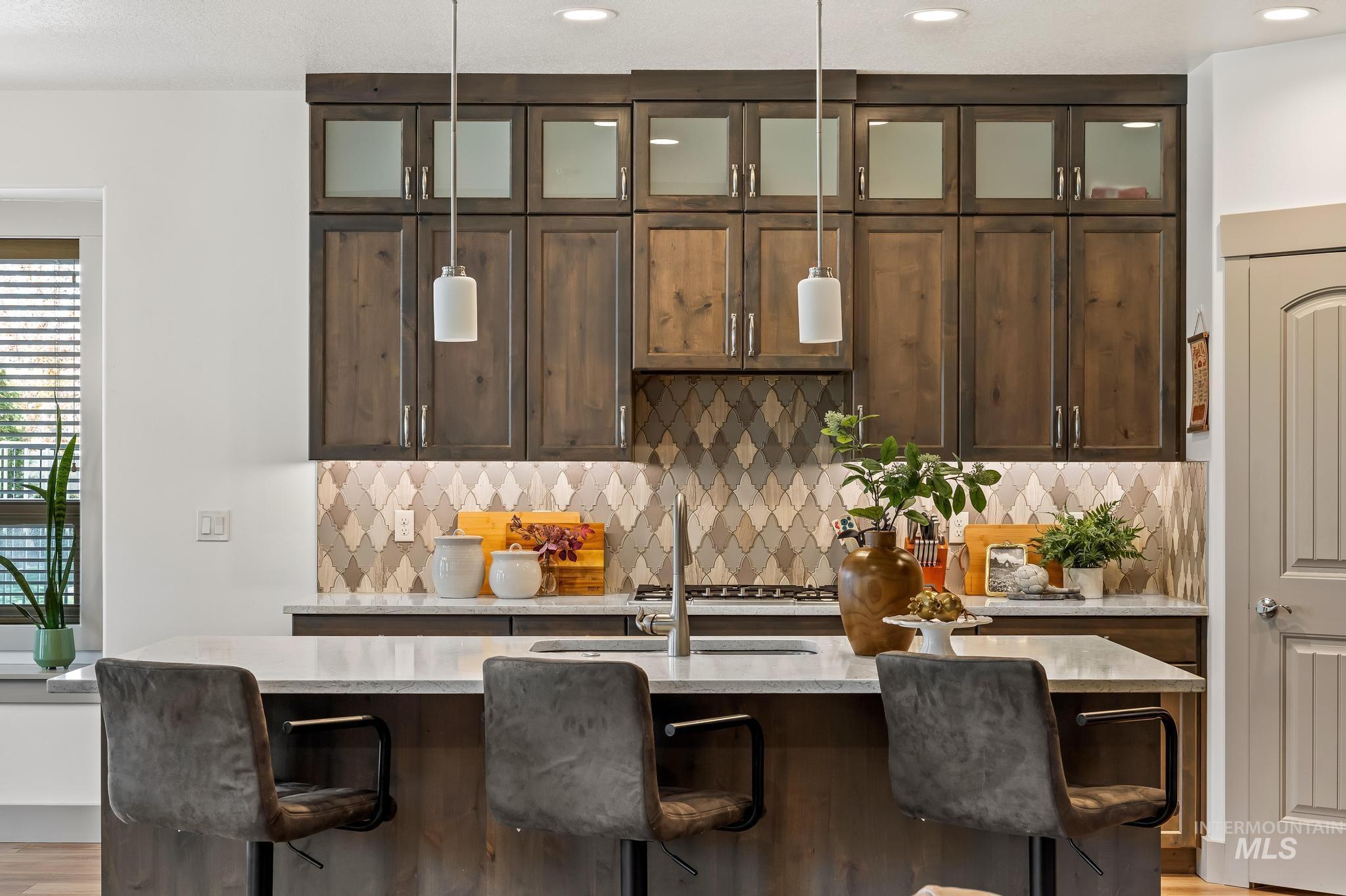 Kitchen featuring dark brown cabinetry, pendant lighting, tasteful backsplash, and recessed lighting