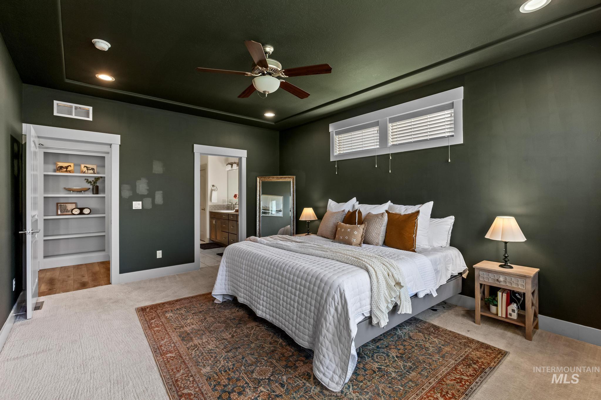 Bedroom with light carpet, recessed lighting, ceiling fan, and ensuite bath