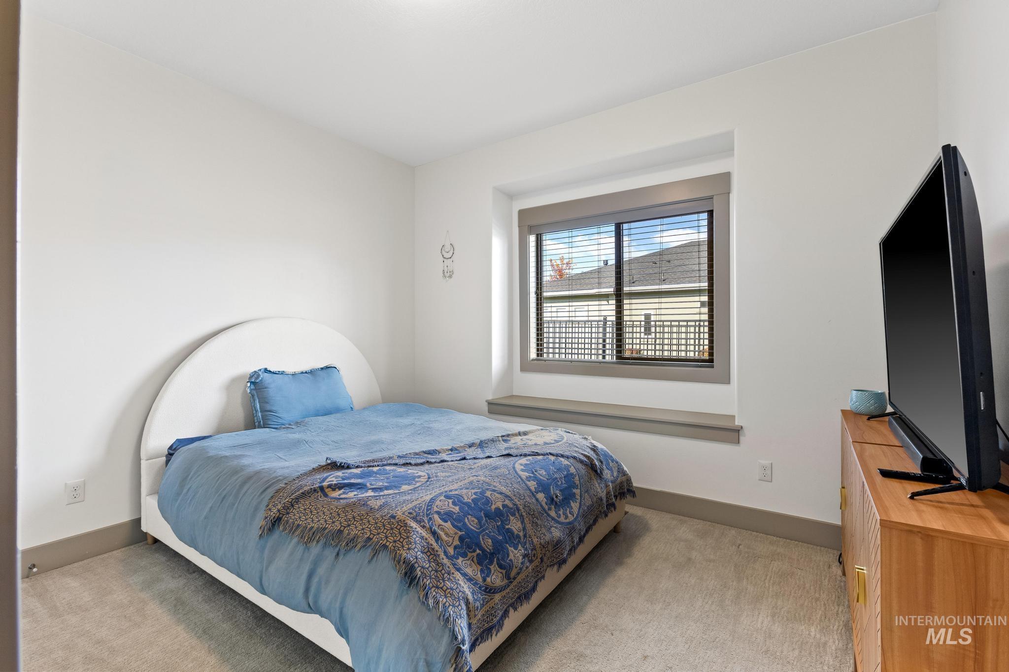 Bedroom with light carpet and baseboards