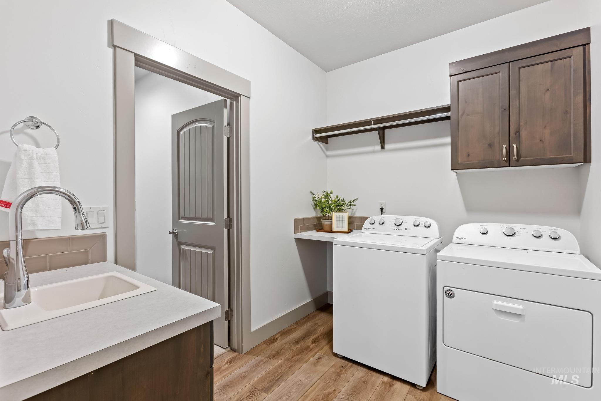 Laundry room featuring cabinet space, light wood-style flooring, and washer and dryer