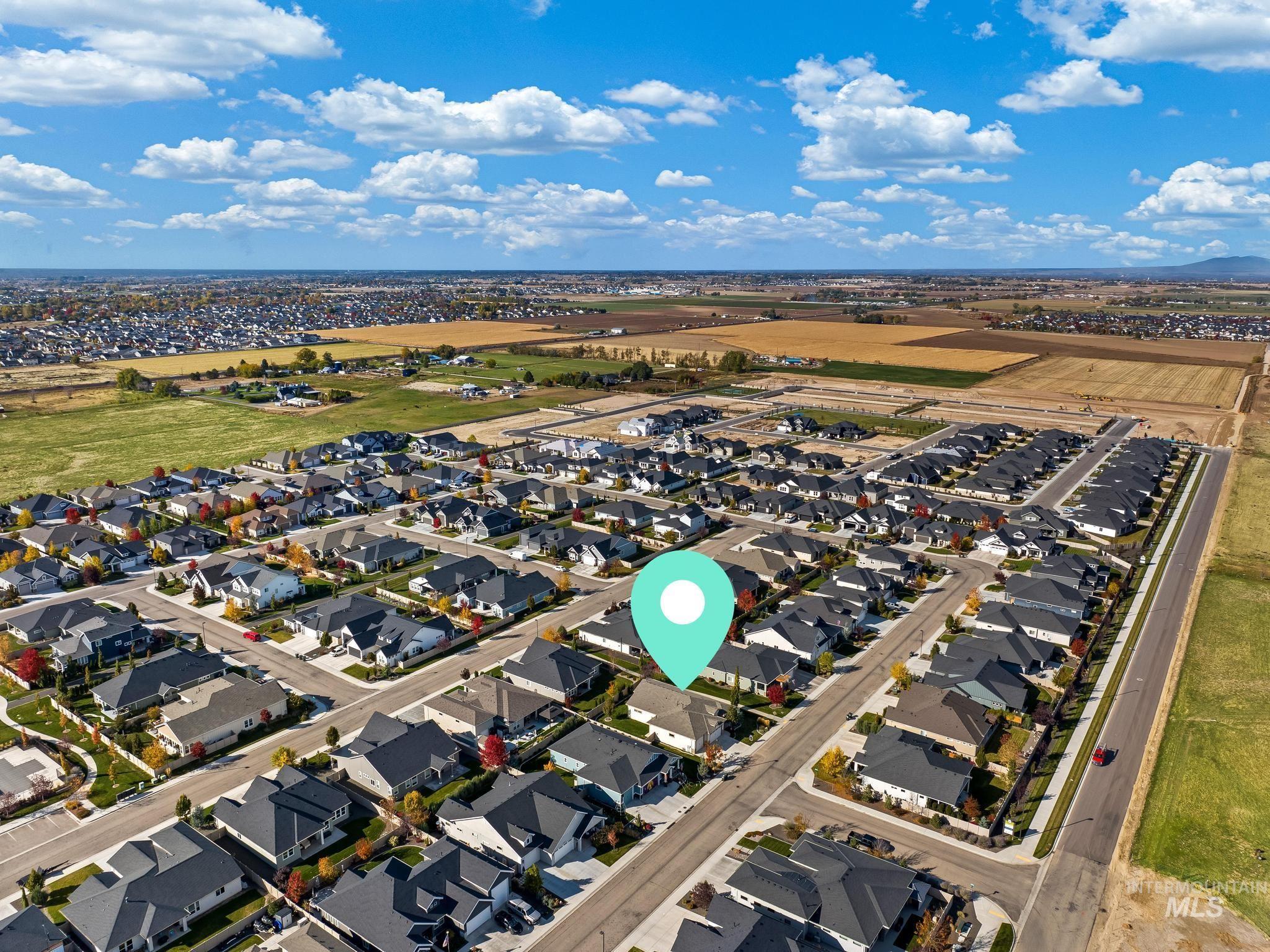 Aerial view of property and surrounding area featuring nearby suburban area
