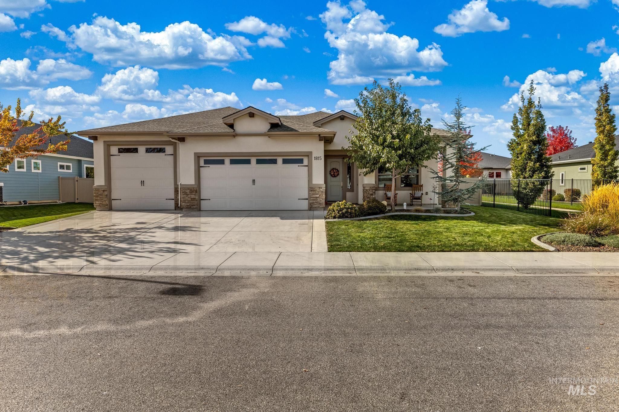 View of front of house featuring driveway, a garage, stucco siding, and stone siding