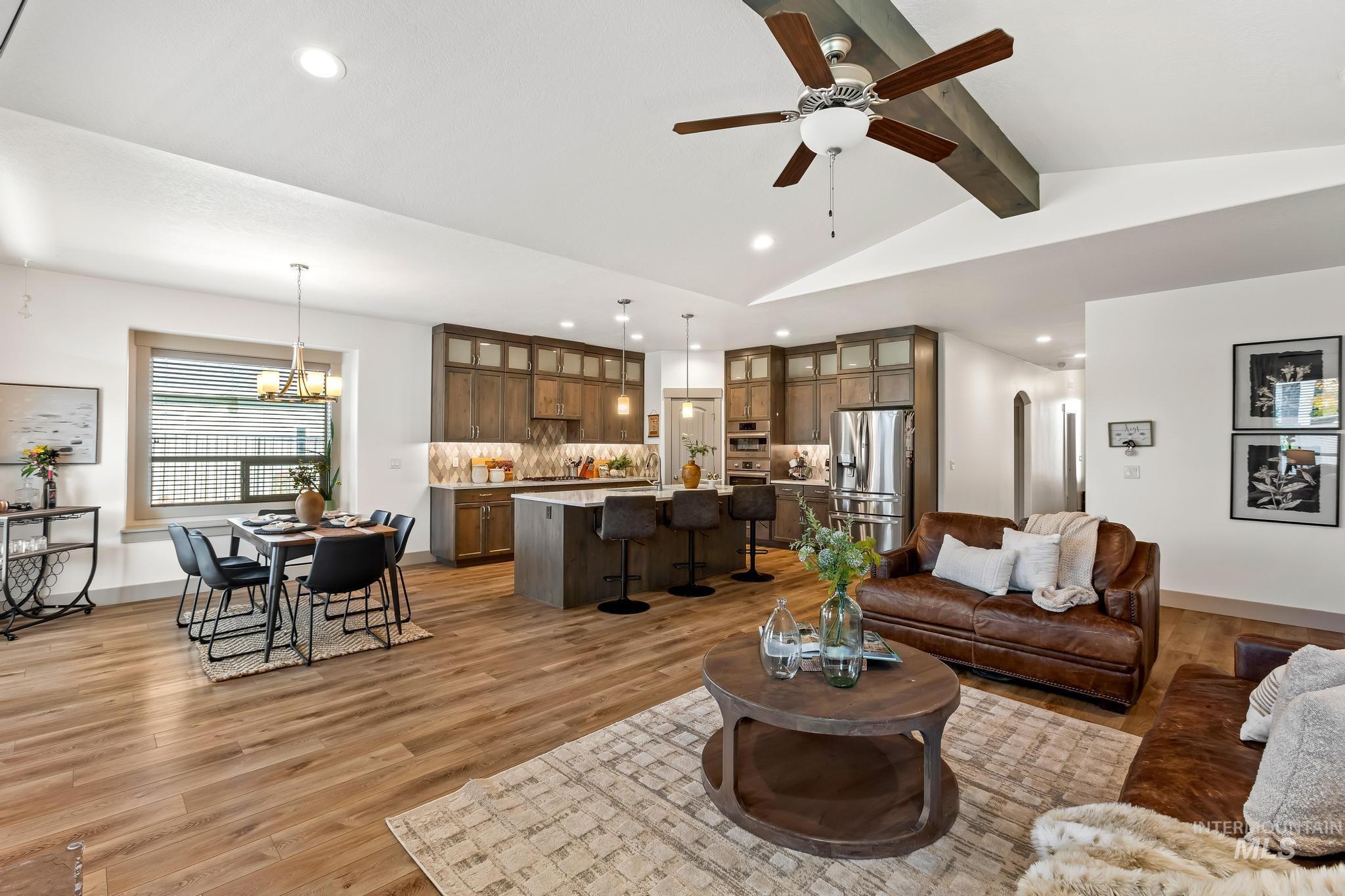Living room featuring light wood-style flooring, recessed lighting, a ceiling fan, and a chandelier