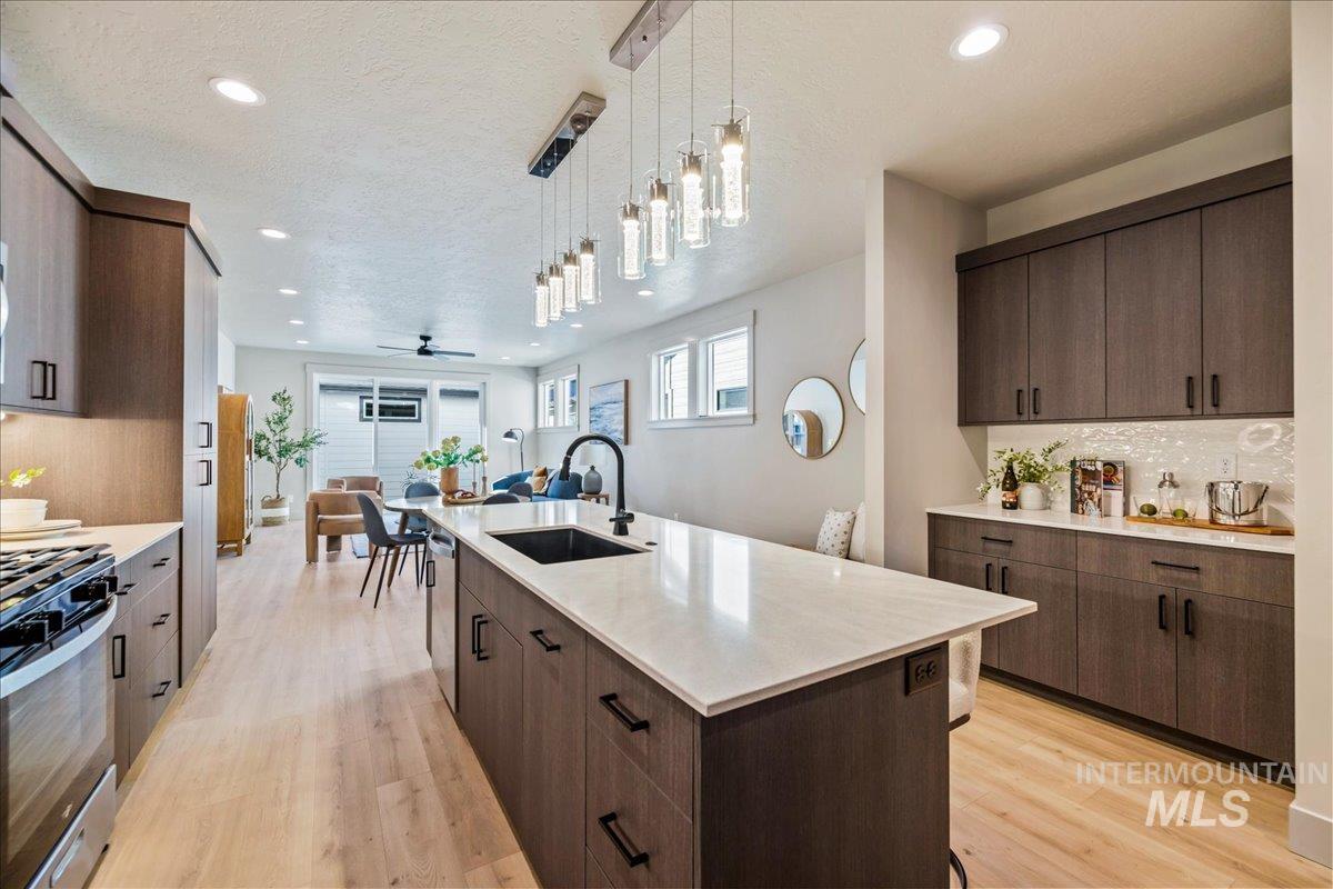Kitchen featuring decorative backsplash, hanging light fixtures, light wood-style floors, open floor plan, and recessed lighting