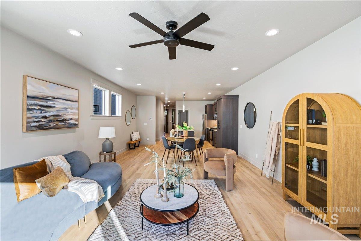 Living room with light wood finished floors, recessed lighting, and a ceiling fan