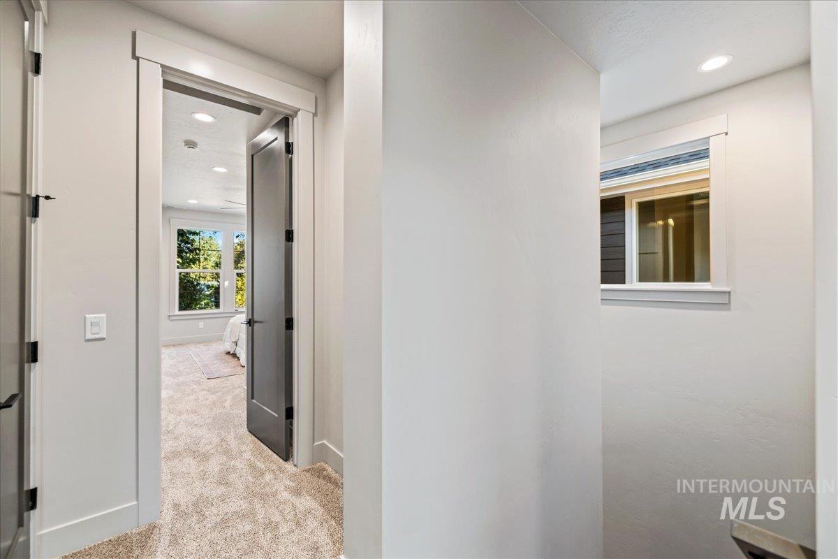 Corridor with light carpet and recessed lighting